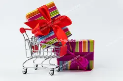 عکس با کیفیت جعبه های هدیه یا کادوی رنگارنگ با روبان بزرگ قرمز رنگ کنار و درون سبد خرید از مراکز خرید ویژه استفاده در امور تبلیغاتی و تجاری طراحی کاتالوگ ، بروشور و تراکت با موضوع خرید کادو و هدیه ، مراکز خرید ، هایپرمارکت و فروشگاه های بزرگ