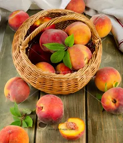 عکس با کیفیت میوه های هلو درون سبد حصیری و روی میز چوبی