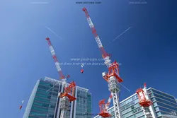 عکس با کیفیت دو تاور کرین بلند به رنگ های سفید و قرمز در کنار برج ها مناسب برای چاپ ویژه شرکت های ساختمانی و هولدینگ های ساختمان سازی و انبوه سازان