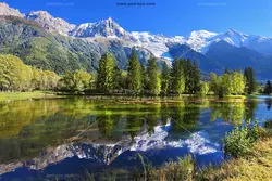 عکس با کیفیت زیبای درختان در کنار برکه با انعکاس تصویر درختان در آب برکه یا دانلود عکس درختان صنوبر در کوه های نزدیک دریاچه یخی، مه در کوه های زمستانی چشم انداز طبیعت زمستانی ، چشم انداز دریاچه کوهی عرضی و قله های برفی