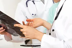 عکس با کیفیت گفتگوی پزشکان متخصص با لباس سفید درباره عکس رادیولوژی بیمار