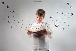 عکس با کیفیت مطالعه کتاب توسط کودک در بین حروف زبان انگلیسی یا دانلود عکس پسر بچه در حال خواندن کتاب زبان انگلیسی و حروف لاتین