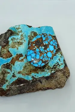 سنگ فیروزه کلکسیونی نیشابوری، بی نظیر در طبع و رنگ، کمیاب و خاص، رنگ چشم نواز آبی، ذات عالی شجری لانه زنبوری، جلای سرامیکی و فوق العاده درخشان، تراش بیضی باب رکاب، اصل نیشابور، زنده و طبیعی.