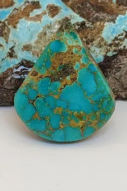 فیروزه کلکسیونی و خاص نیشابوری، بی نظیر در طبع و رنگ، رنگ سبز اقیانوسی، ذات عالی شجری عنکبوتی با رگه های طلائی رنگ، جلای سرامیکی و بسیار درخشان، تراش اشکی مدالی درشت و قواره دار، اصیل و زنده با رنگ طبیعی