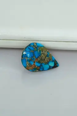 سنگ فیروزه نیشابور، بسیار زیبا و خاص، بی نظیر در طبع و رنگ، رنگ آبی محک، ذات عالی شجری لانه زنبوری، جلای سرامیکی و فوق العاده درخشان، تراش اشکی دامله باب رکاب، اصیل و زنده با رنگ طبیعی.