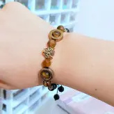 دستبند مردانه سنگ چشم ببر و حدید طلایی و سر ببر سوارسکی و اونیکس مشکی زیورآلات دستساز رنگ ثابت