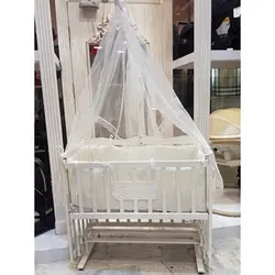 گهواره چوبی و تخت کنار مادر