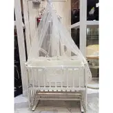 گهواره چوبی و تخت کنار مادر