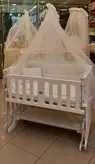 گهواره چوبی و تخت کنار مادر