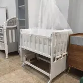 گهواره چوبی و تخت کنار مادر