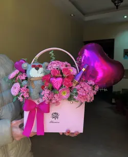 گل صورتی و عروسک و بادکنک داخل فلاوربگ فلوبار