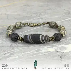 دستبند مهره لول عقیق سلیمانی مشکی مات طرح قدیمی با نقش و نگار زیبا همراه عقیق تبتی چشمی و لاوا طبیعی