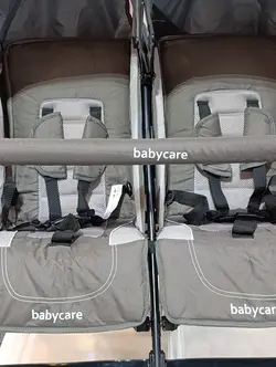 کالسکه دوقلو عصایی بغل هم رنگ طوسی خاکی بیبی کر با گارد محافظ جلو کالسکه  Baby Care Double Stroller