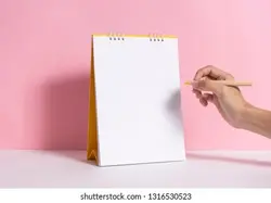 Hand holding pencil for writing marking on mockup paper spiral calendar on pink background. | مداد نگه داشتن دست برای نوشتن مارک در تقویم مارپیچ کاغذ Mockup در پس زمینه صورتی. – آکادمی پرنیان طرح