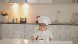 فوتیج دختری پشت میز نشسته و ماست می‌خورد و شیر می‌نوشد