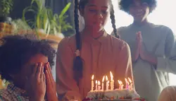 فوتیج کودک سیاه پوست در حال دمیدن شمع روی کیک تولد
