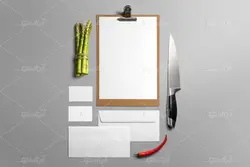 موکاپ برگه روی تخته شاسی در کنار نان فانتزی و فلفل  روی میز