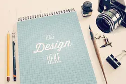 موکاپ دفترچه طراحی همراه با قلم و خودکار با دوربین عکاسی
