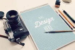 موکاپ دفترچه طراحی همراه با قلم و خودکار با دوربین عکاسی