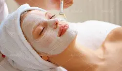 عکس با کیفیت خانم دراز کشیده روی تخت پاکسازی پوست  با ماسک صورت