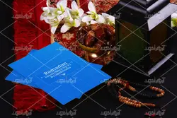 موکاپ پوشه و دفترچه روی میز و ظرف خرما کنار فانوس