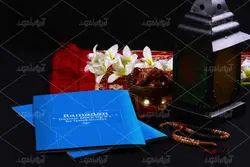 موکاپ پوشه و دفترچه روی میز و ظرف خرما کنار فانوس