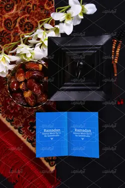 موکاپ پوشه و دفترچه روی میز و ظرف خرما کنار فانوس