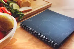 موکاپ لبتاب و دفترچه روی میز و پس زمینه آشپزخانه