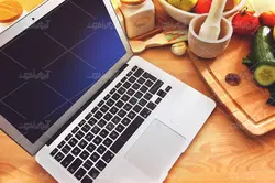 موکاپ لبتاب و دفترچه روی میز و پس زمینه آشپزخانه