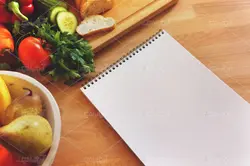 موکاپ لبتاب و دفترچه روی میز و پس زمینه آشپزخانه
