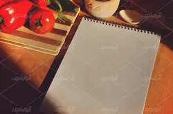 موکاپ لبتاب و دفترچه روی میز و پس زمینه آشپزخانه