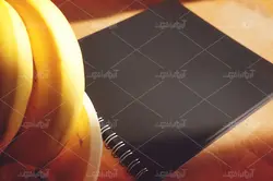 موکاپ لبتاب و دفترچه روی میز و پس زمینه آشپزخانه