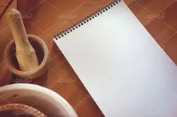 موکاپ لبتاب و دفترچه روی میز و پس زمینه آشپزخانه
