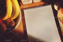 موکاپ لبتاب و دفترچه روی میز و پس زمینه آشپزخانه