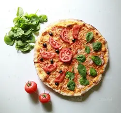 عکس با کیفیت از پیتزای برش خورده با سبزی و گوجه