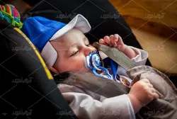 دانلود عکس با کیفیت نوزاد با پستونک در کالسکه با کلاه آبی زیبا