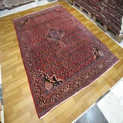 فرش دستباف بيجار طرح لچک و ترنج سایز قالي رنگ زمینه لاكي رنگ حاشیه سرمه اي کد ۳۹۴۵۲