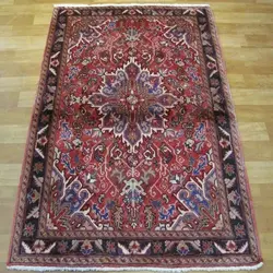 فرش دستباف هريس طرح لچک و ترنج سایز ذرع و نيم رنگ زمینه لاكي رنگ حاشیه سرمه اي کد ۳۹۵۵۹